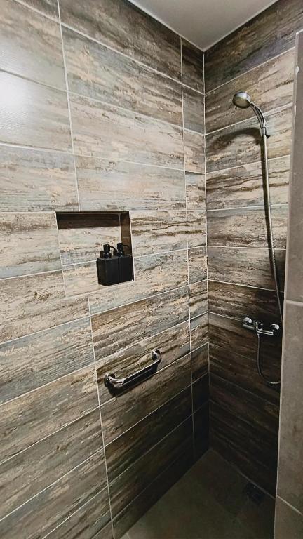 Łazienka z prysznicem i ścianą wyłożoną kafelkami w obiekcie Wincarayen Lodge & Cabañas w mieście Panguipulli