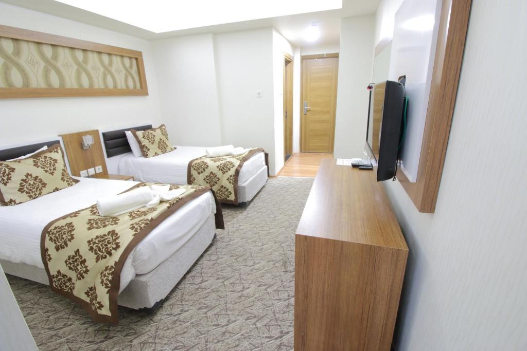Postel nebo postele na pokoji v ubytování Afyon Grand Arı Hotel