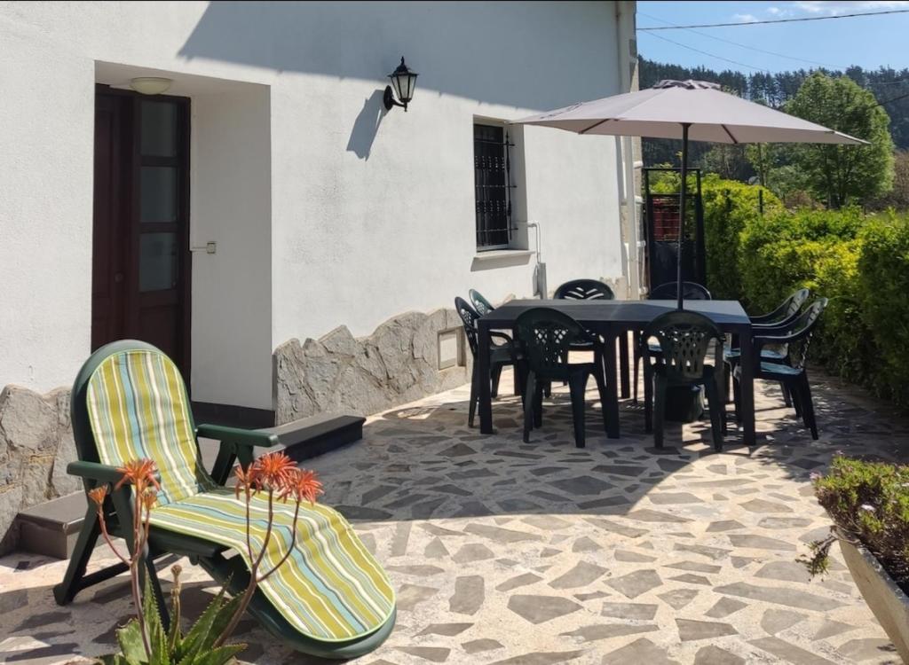 patio ze stołem, krzesłami i parasolem w obiekcie KABIXA ETXEA Casa Rural, Lekeitio w mieście Guizaburuaga