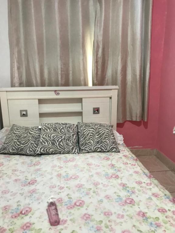 a bedroom with a bed with a head board at Casa confortável a 5 minutos da Praia do Forte a pé in Cabo Frio