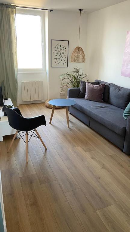 un salon avec un canapé bleu et une table dans l'établissement Le Spot, appartement cosy à 1mn de la mer, Saint Aubin sur Mer, à Saint-Aubin-sur-Mer