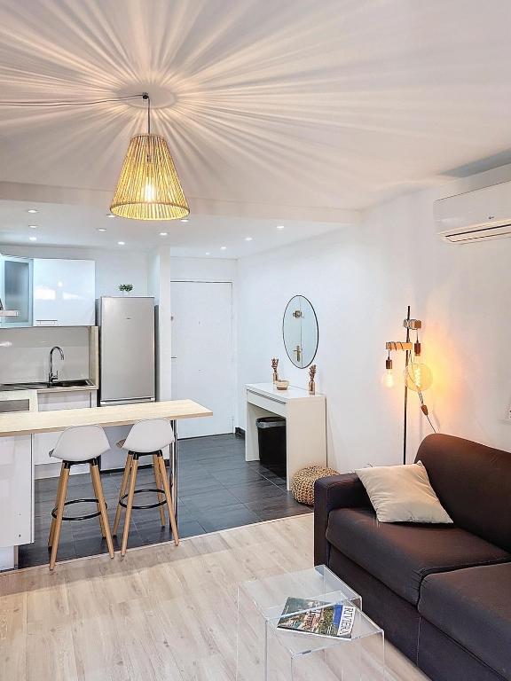 un salon avec un canapé et une table et une cuisine dans l'établissement Appartement avec grande terrasse, à Saint-Laurent-du-Var