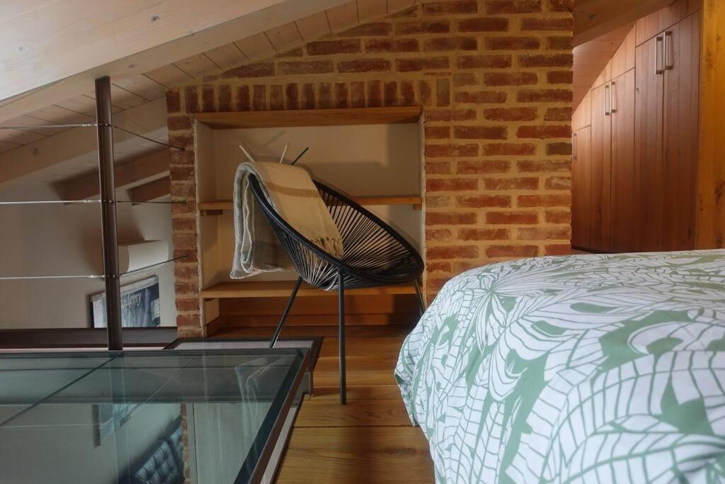 Pokój z łóżkiem i szklanym stołem w obiekcie Loft Cùntra Maestra w Asti