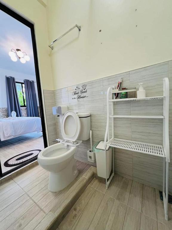 uma casa de banho com um WC branco num quarto em Hidden Valley em Siquijor