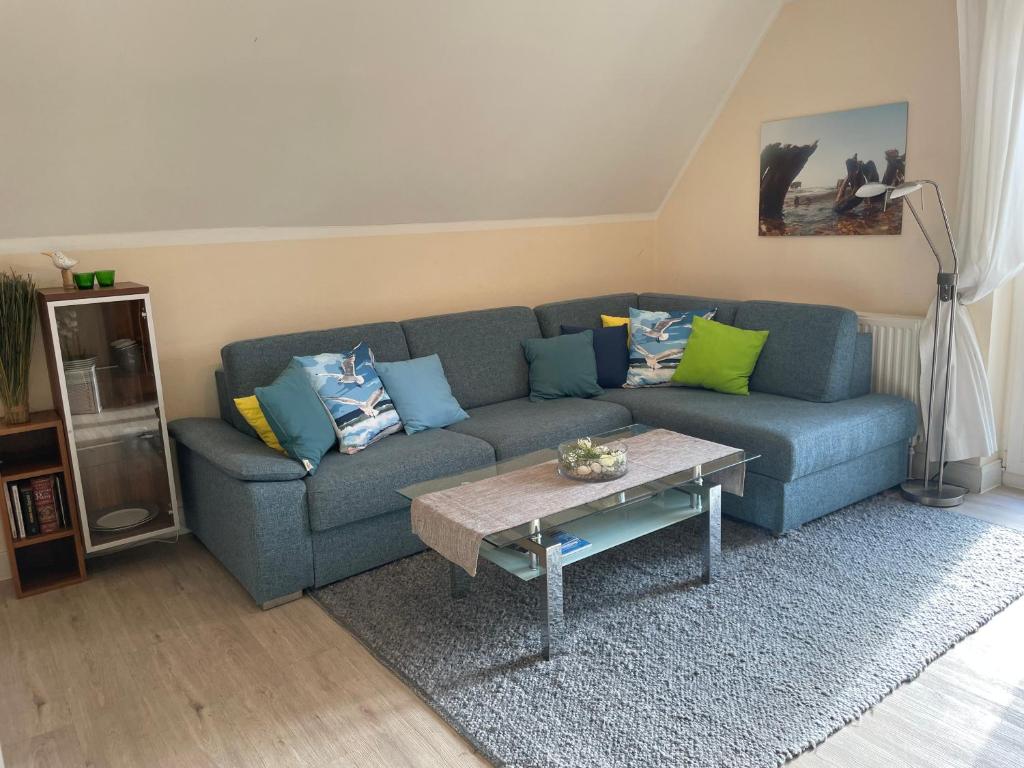 a living room with a blue couch and a coffee table at Ferienwohnung Möövnest in Prerow