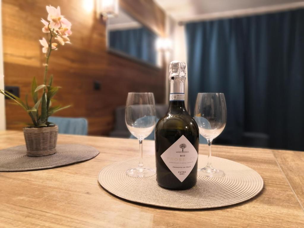 eine Flasche Wein auf dem Tisch mit zwei Weingläsern in der Unterkunft Himalaya - Apartments in Prato Nevoso
