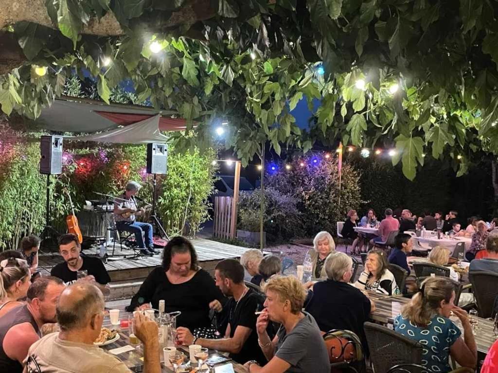 un groupe de personnes assises à table dans un restaurant la nuit dans l'établissement Chalet 3 étoiles - ccaaafc, à Sorèze