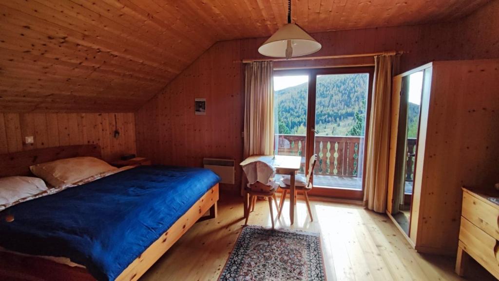 a bedroom with a bed and a table and a window at Ferienhaus Vier Jahreszeiten in Reichenau