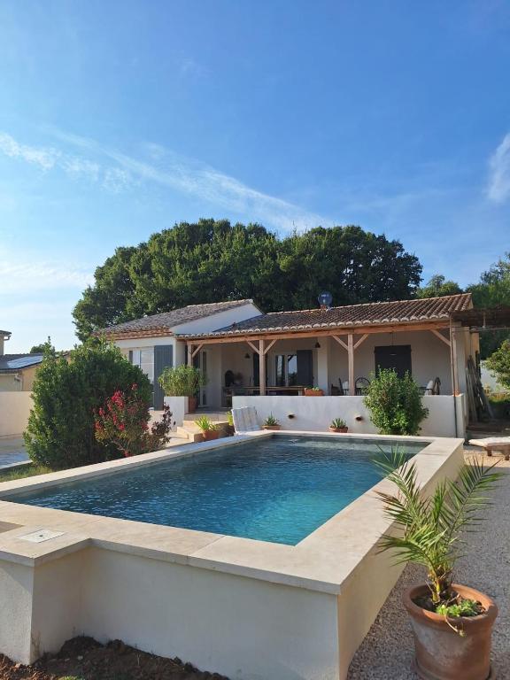 une piscine devant une maison dans l'établissement Les Cigales de Saint Quentin la Poterie, à Saint-Quentin-la-Poterie