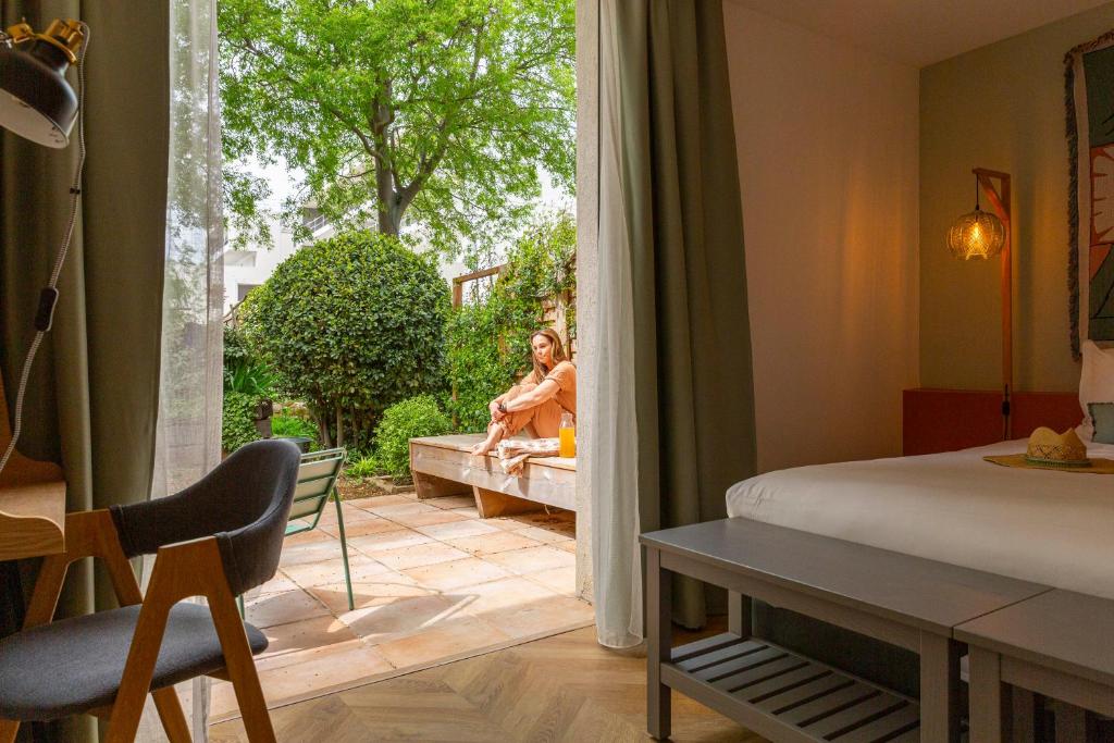 two women sitting on a bench in a room with a window at Hôtel 96 in Marseille