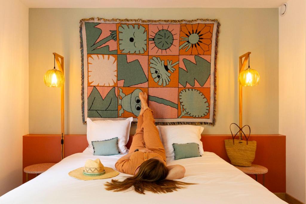 a woman laying on top of a bed with her head at Hôtel 96 in Marseille