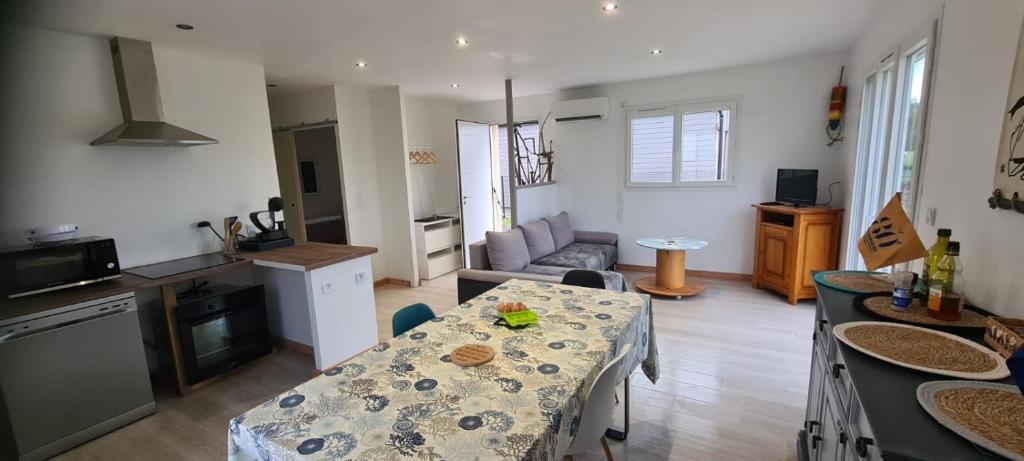 un salon avec une table et une cuisine dans l'établissement Le Ponton de Magny-en-Bessin, à Magny-en-Bessin