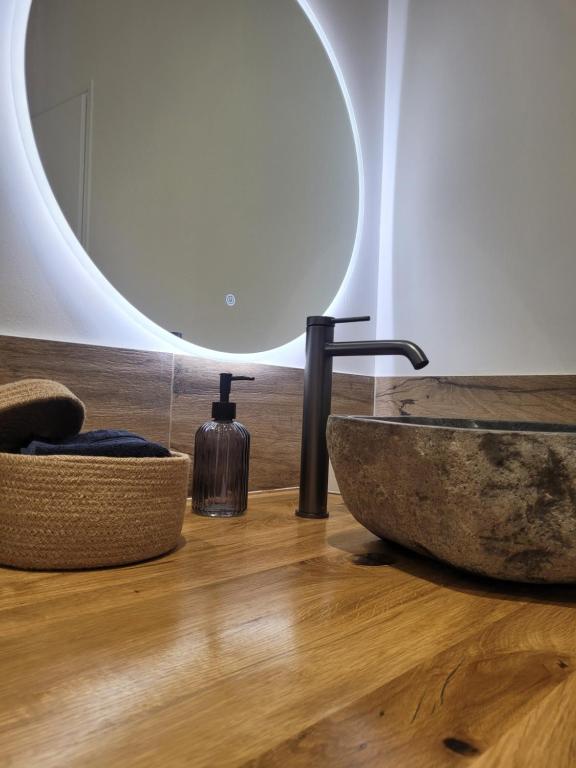 une salle de bain avec un lavabo en pierre et un miroir dans l'établissement Appartement Au cœur de l'Isle, à LʼIsle-sur-la-Sorgue