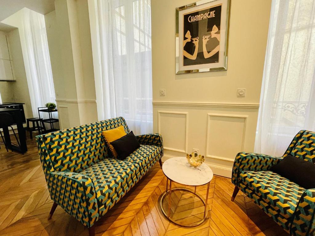 un salon avec deux chaises et une table dans l'établissement Appartement de charme Art Déco - Hyper-centre ville - Place d'Erlon - Gare - Reims, à Reims