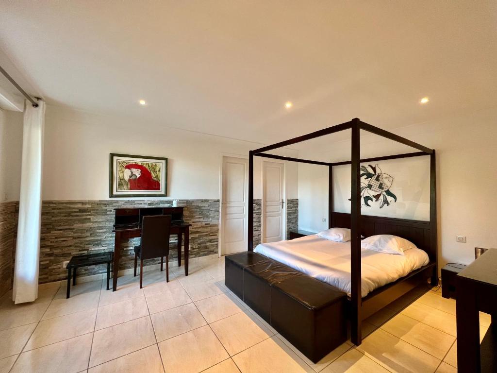 昂叙埃拉雷东Appartement "Calanques" - Domaine Ciel et Mer的一间卧室配有天蓬床和餐桌