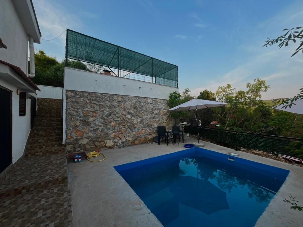 a swimming pool in the backyard of a house at Apartments Mudrić in Herceg-Novi