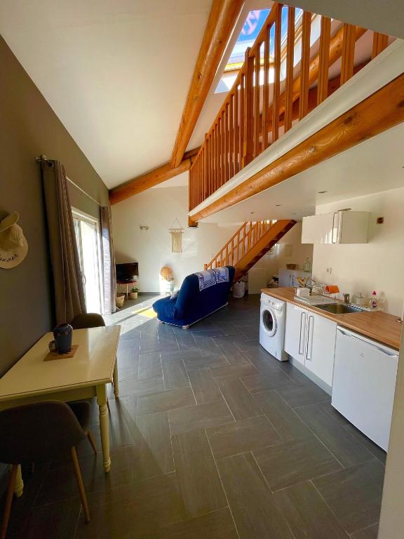 un salon avec une cuisine et un escalier dans l'établissement Appartement Cosy avec extérieur au calme, à Rocbaron