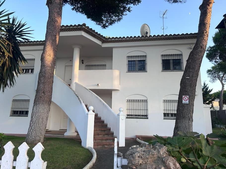 een wit huis met een witte trap en bomen bij Apartamento La Barrosa Beach in Novo Sancti Petri