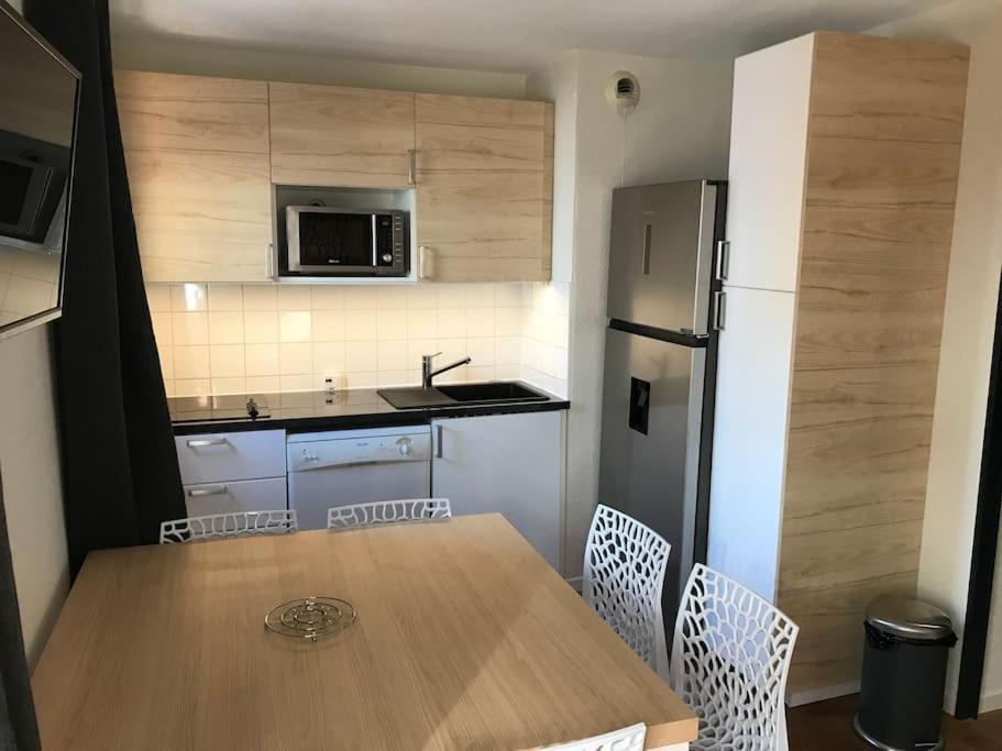 une cuisine avec une table en bois et un réfrigérateur dans l'établissement Appartement 8 personnes, au pied des pistes, à Saint-François-Longchamp