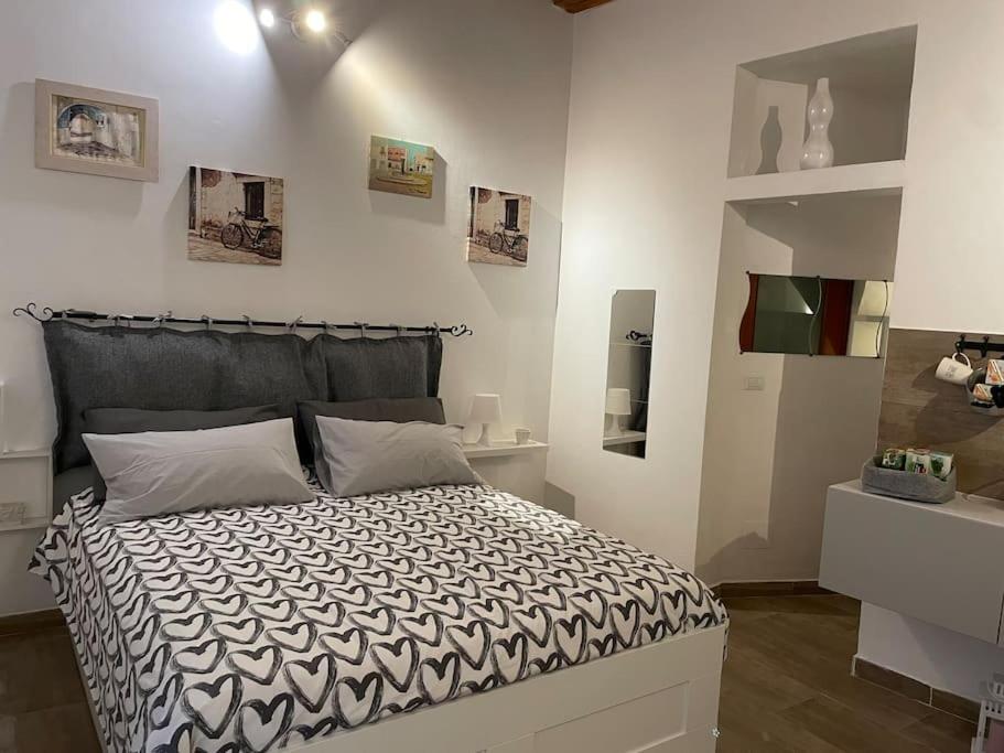 a bedroom with a bed and a white wall at Le Colonne 14 in Bari
