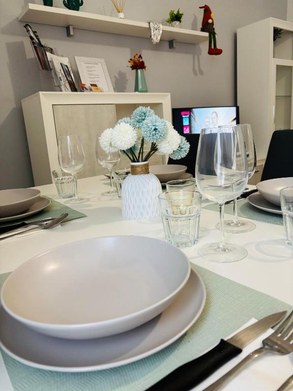 a table with a white plate and wine glasses at El Descanso de Rocinante in Almagro