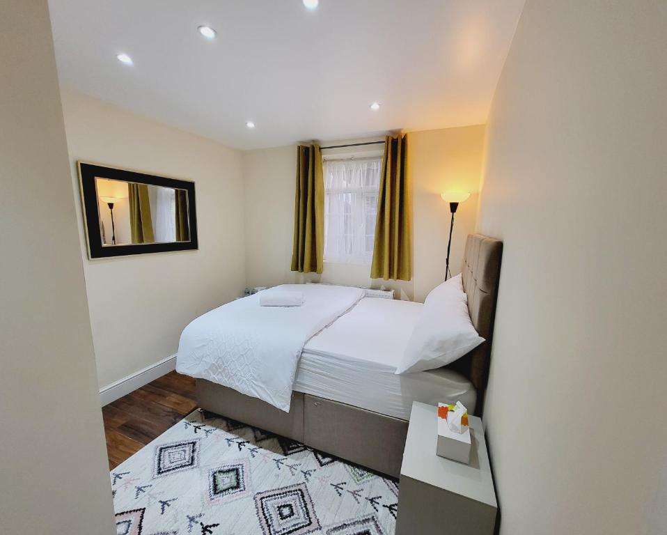 a small bedroom with a bed and a mirror at Nest & Rest En-Suite in Ashford