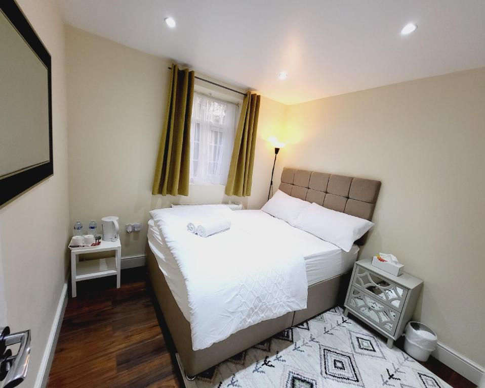 a small bedroom with a bed and a window at Nest & Rest En-Suite in Ashford