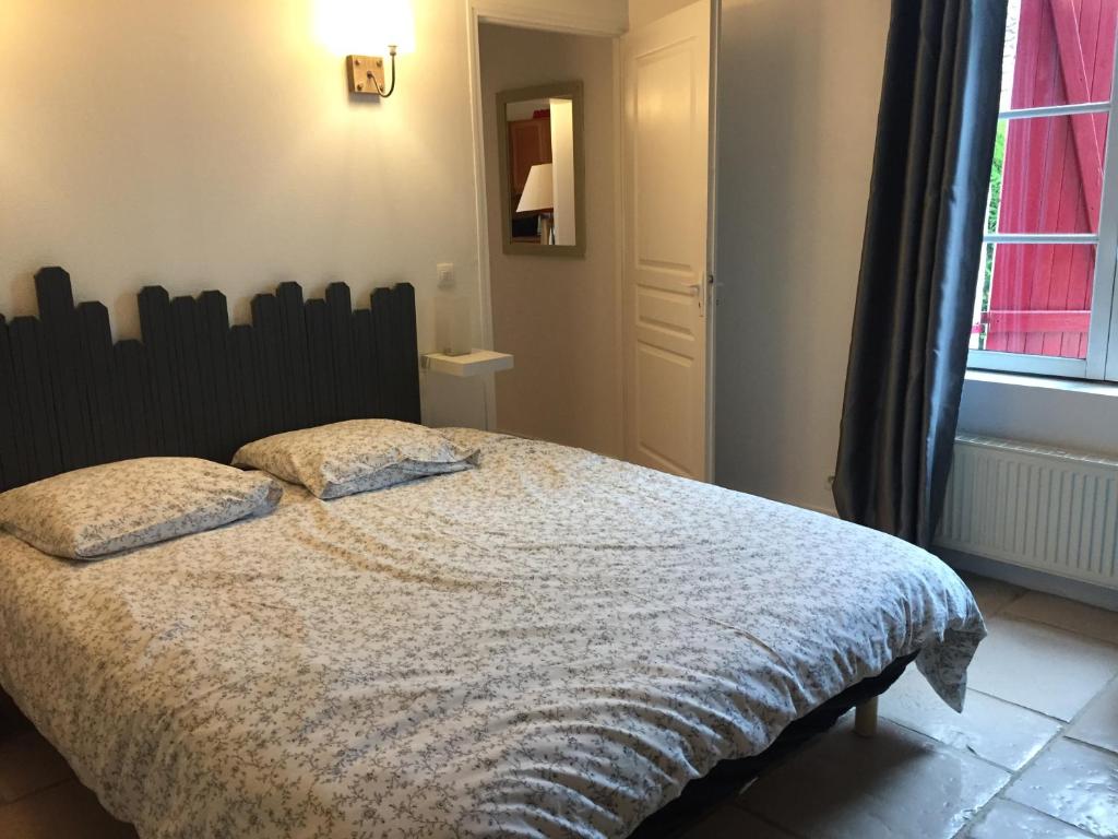 una camera da letto con un letto e una finestra di Gîte tout équipé au calme a Saint-Amand-les-Eaux