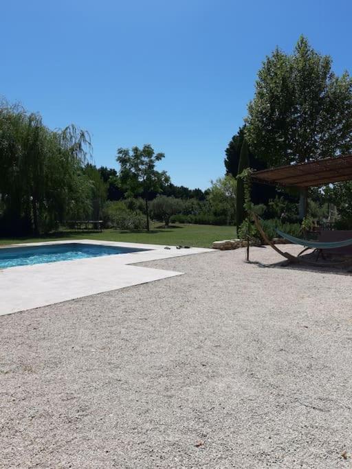 - une piscine avec une table et un banc à côté dans l'établissement Beau mas en campagne de l'Isle sur la Sorgue, à LʼIsle-sur-la-Sorgue