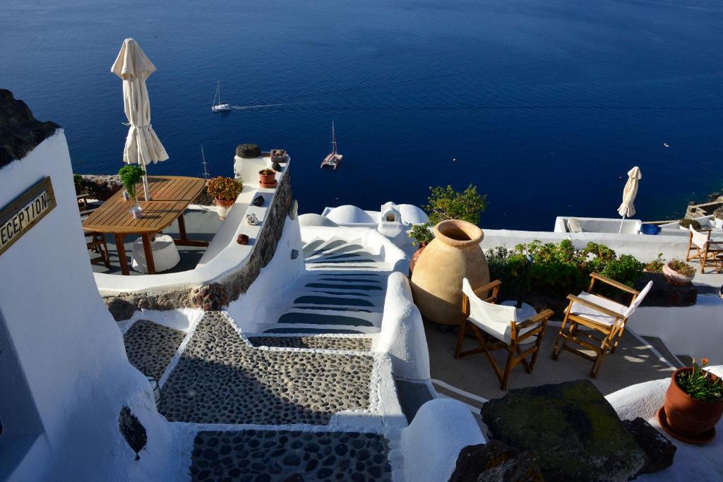 uma escada que leva a um pátio com vista para o oceano em Rimida Villas em Oia