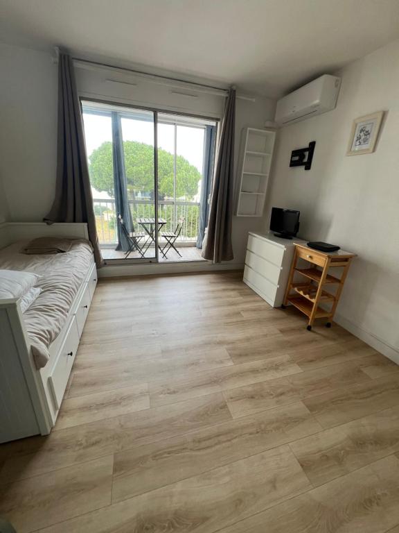 une chambre avec un lit, un bureau et une fenêtre dans l'établissement Studio Stone Brooke, à La Grande Motte