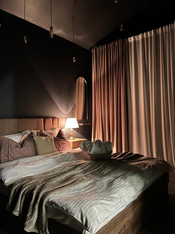 ein Schlafzimmer mit einem großen Bett mit einem Teddybär darauf in der Unterkunft Calypso House in Jiblea Veche