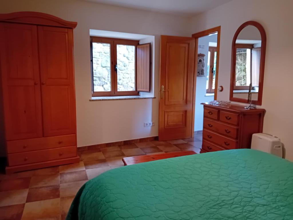 sypialnia z zielonym łóżkiem i komodą w obiekcie Stone Cottage O CEBREIRO w mieście Curtis