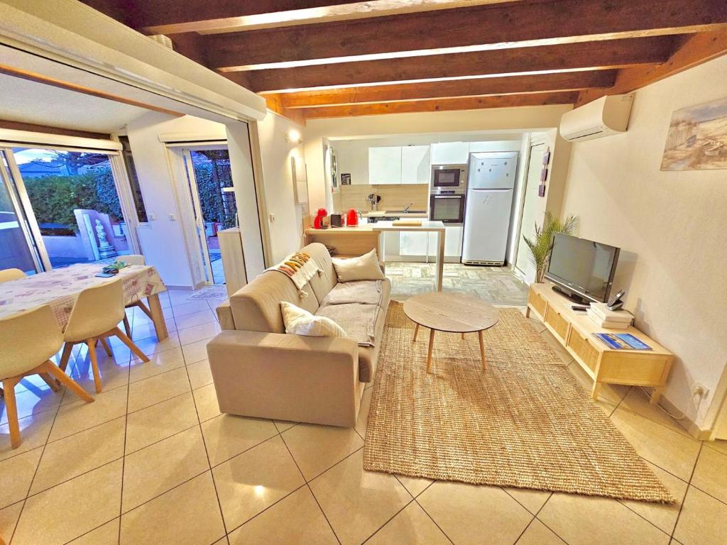 un salon avec un canapé et une table dans l'établissement Villa au calme à 200m de la plage de Rochelongue, au Cap d'Agde
