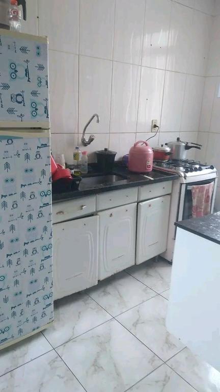 a kitchen with a stove and a refrigerator with writing on it at Praia in Guarujá