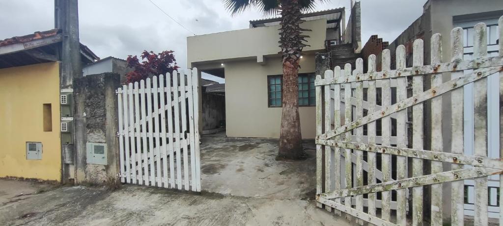a white fence in front of a house at Casa praia in Peruíbe