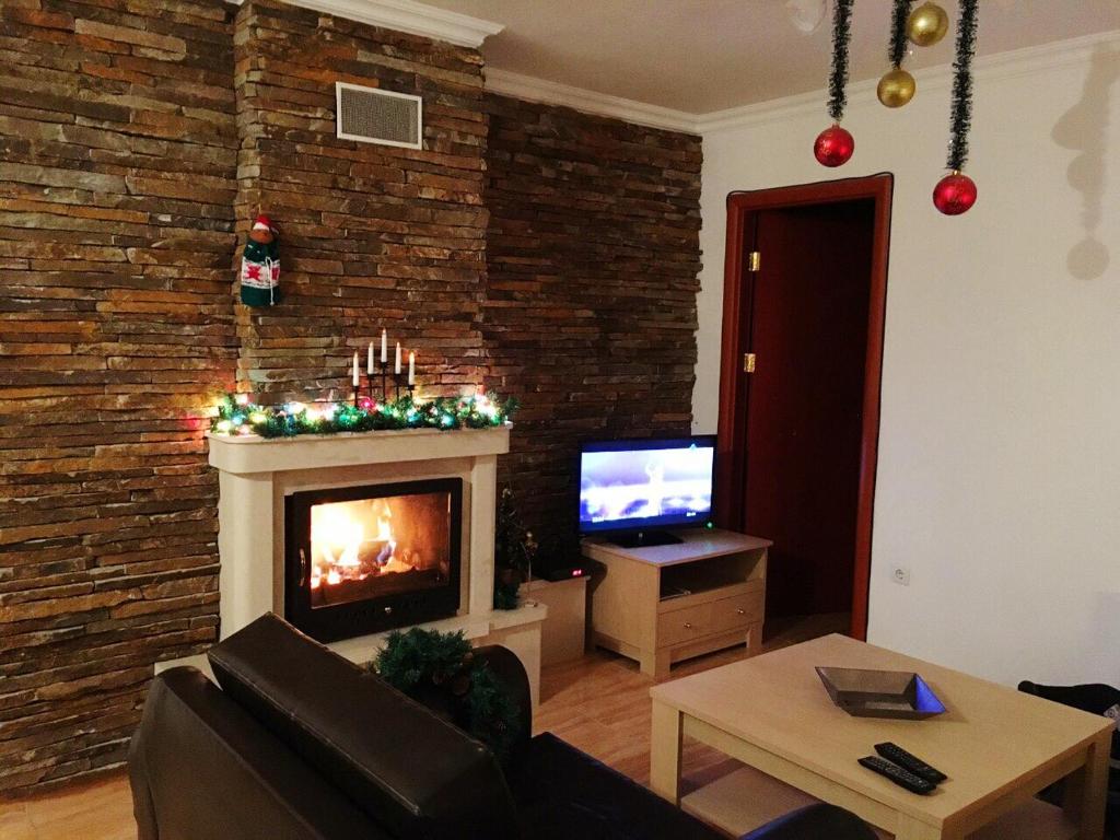 a living room with a fireplace and a television at Grand Monastery 3 Apartment 10 in Pamporovo