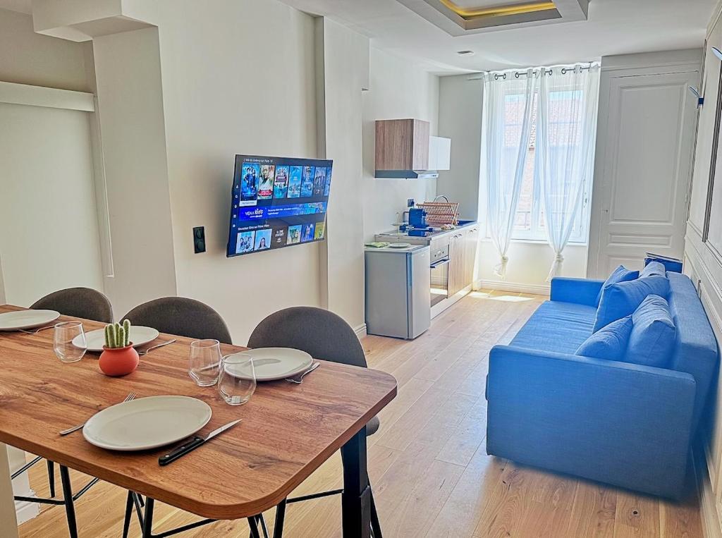 un salon avec une table et un canapé bleu dans l'établissement chic & élégant, à Villeurbanne