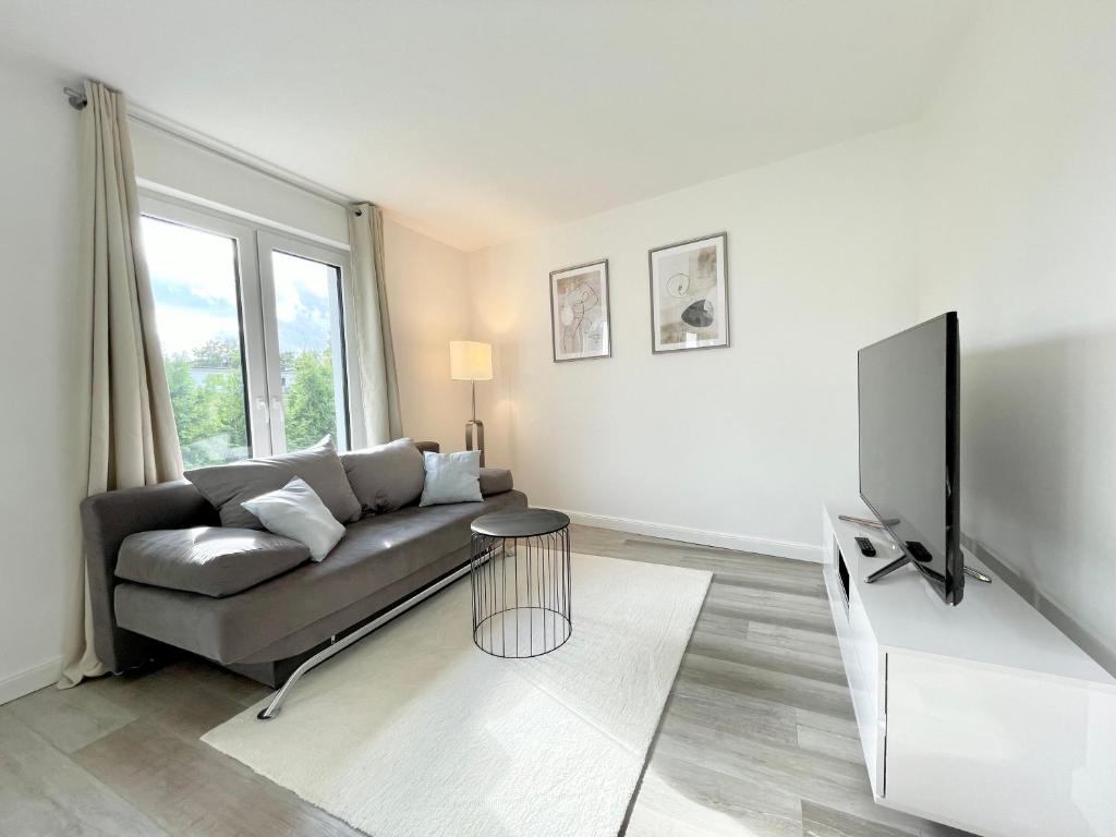 TV a/nebo společenská místnost v ubytování Moderne-Neubauwohnung mit Stellplatz
