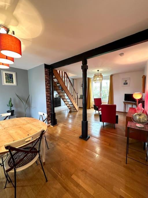 une salle à manger et un salon avec une table et des chaises dans l'établissement Duplex de charme à Valognes, à Valognes
