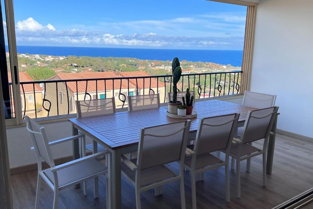 une table et des chaises sur un balcon avec vue sur l'océan dans l'établissement T4-80m2 superbe vue mer Sant Ambroggio, à Lumio