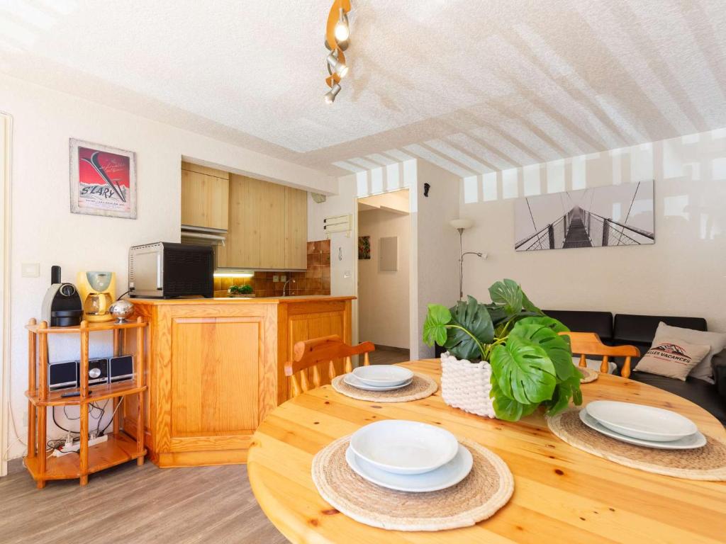 d'un salon avec une table et des plaques de cuisson. dans l'établissement Confort au centre de Saint Lary: T3 avec balcon, cuisine équipée - FR-1-296-505, à Saint-Lary-Soulan