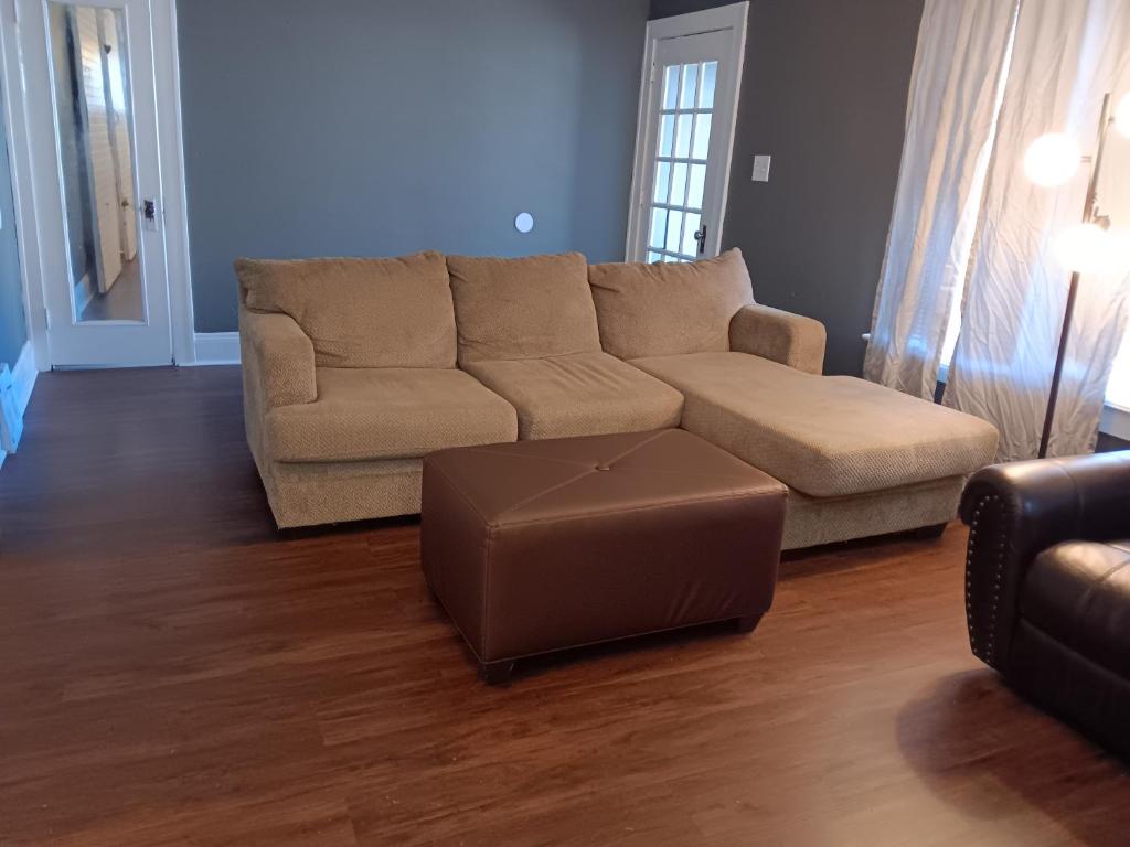 a living room with a couch and a ottoman at Experience a home near Cleveland Clinic & parks in Cleveland