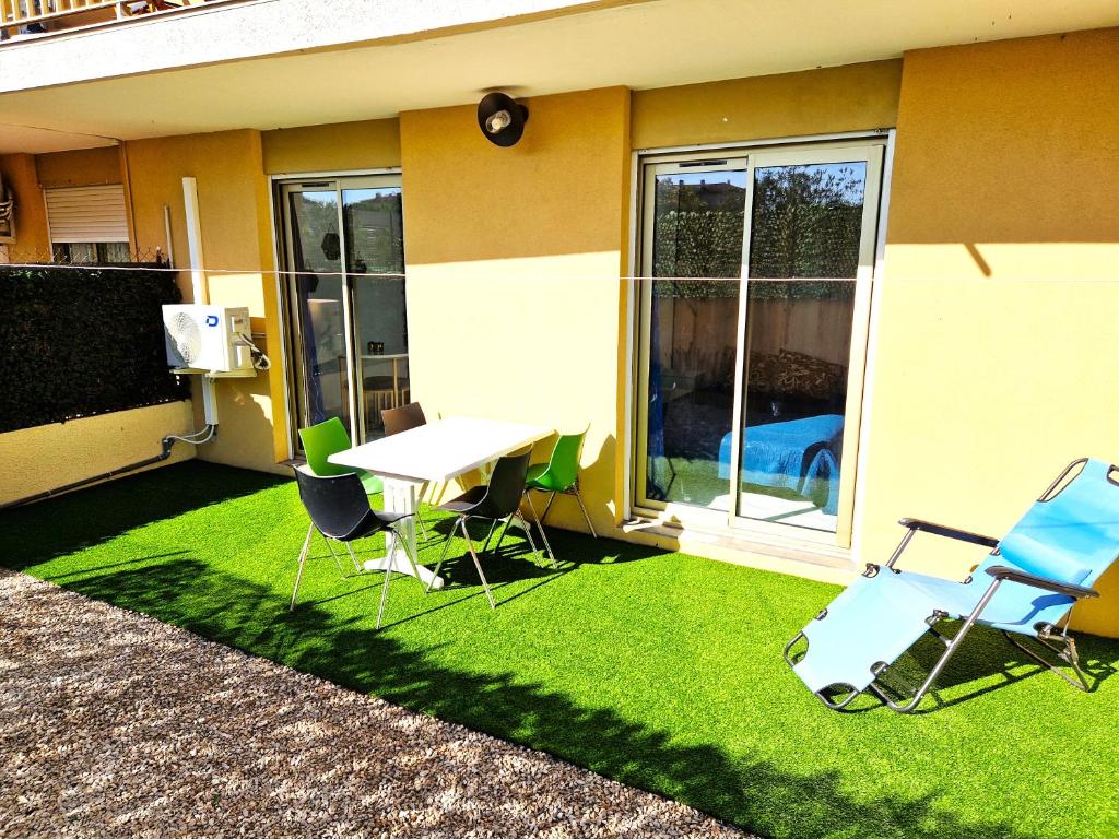 un patio avec une table et des chaises sur l'herbe dans l'établissement Studio proche centre avec terrasse, à Draguignan