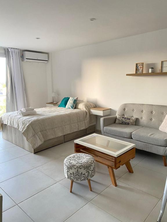 a bedroom with a bed and a couch and a coffee table at Departamento 66 - cochera opcional - in La Plata