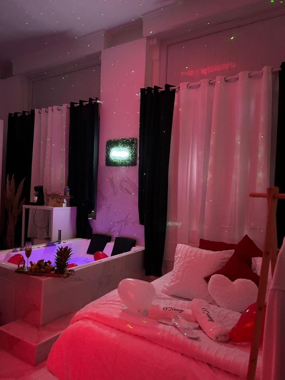 - une chambre avec 2 lits et un éclairage rose dans l'établissement Onuage, à Tourcoing