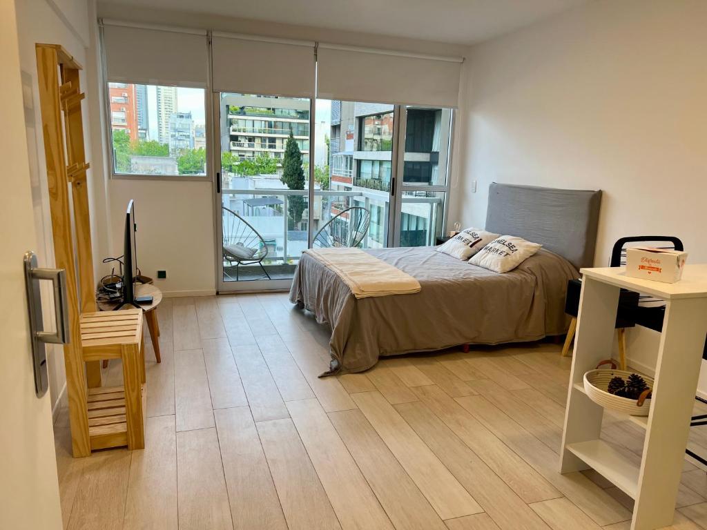 a bedroom with a bed and a large window at Arevalito Monoambiente in Buenos Aires