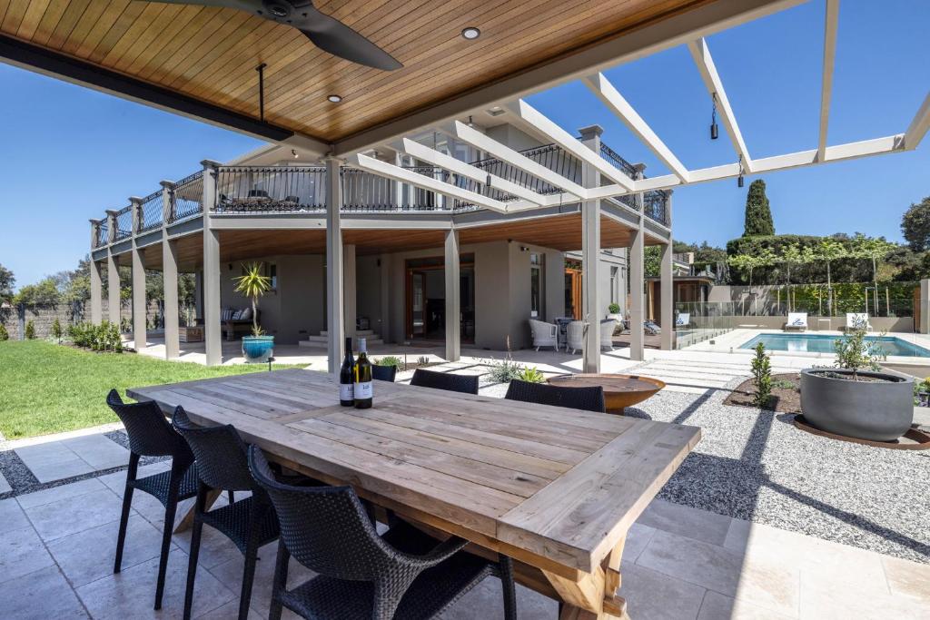 an outdoor patio with a wooden table and chairs at Serendib Luxury Sorrento Resort Living in Sorrento