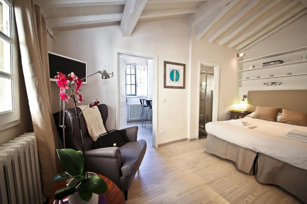 フィレンツェにあるApartments Florence Pinzochere Mansardaのベッドルーム1室(ベッド1台、椅子1脚付)