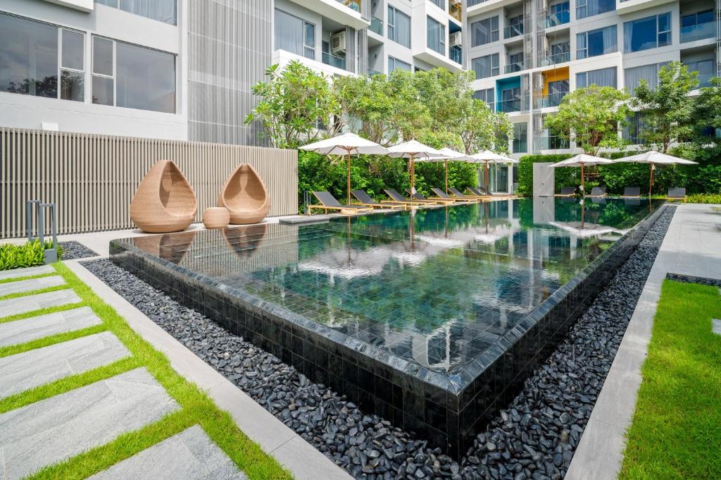 an infinity pool in a building with umbrellas at Laguna Lakeside Residences by Banyan Living in Bang Tao Beach